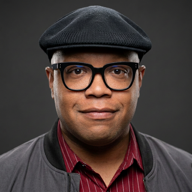 J.D. Boyce wearing glasses and a dark cap
